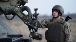 A service member of the Ukrainian Armed Forces stands next to a BM-21 "Grad" multiple rocket launcher during tactical military exercises at a shooting range in Ukraine's Kherson region, Jan. 19, 2022.