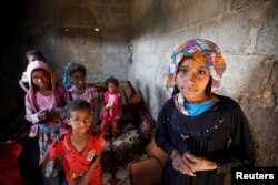FILE - Children displaced from the Red Sea port city of Hodeida stand in their shelter in Sana'a, Yemen, Nov. 1, 2018.
