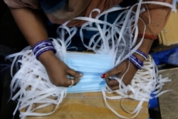 FILE - An Indian laborer works at a surgical mask production unit in Ahmadabad, India, Feb. 1, 2020.