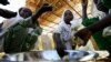 FILE - Internally displaced schoolchildren eat from the same bowl during a feeding program provided by the World Food Program at the Abushouk camp in Al Fasher in North Darfur, Sudan, Nov. 17, 2015.
