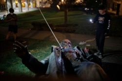 People video the only statue of a Confederate general, Albert Pike, in the nation's capital after it was toppled by protesters and set on fire in Washington, June 20, 2020.