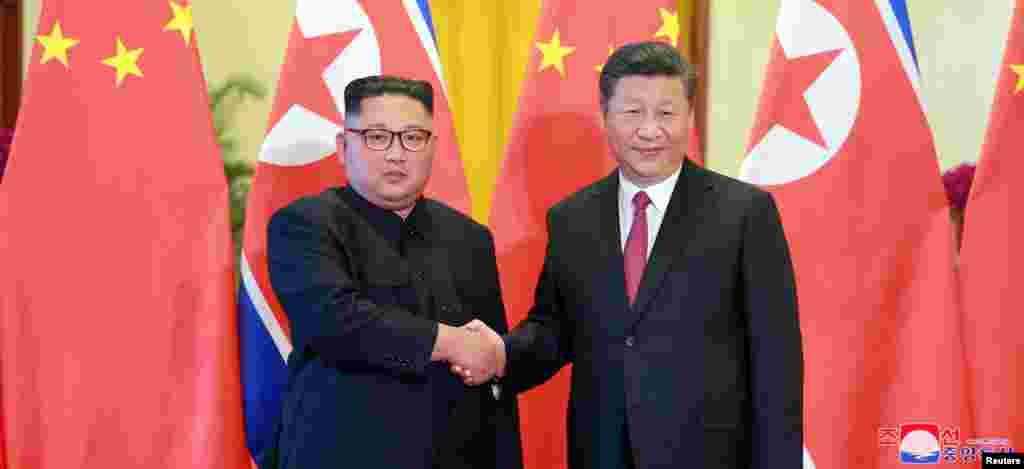 北京人民大会堂的欢迎仪式中中国国家主席习近平和朝鲜领导人金正恩握手(2018年6月19日)。