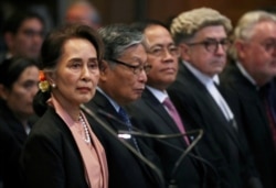Myanmar's leader Aung San Suu Kyi, left, attends a hearing in a case filed by Gambia against Myanmar alleging genocide against the minority Muslim Rohingya population, at the International Court of Justice, Dec.10, 2019.