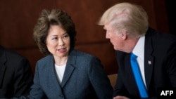 (FILES) In this file photo taken on June 09, 2017, US Transportation Secretary Elaine Chao and US President Donald Trump participate in a roundtable discussion at the US Department of Transportationin Washington, DC.