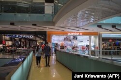 Para pengunjung di sebuah mal di Surabaya, 10 Agustus, 2021. (Foto: Juni Kriswanto/AFP)