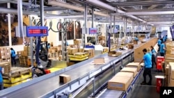 Image taken from video shows people working inside the UNICEF warehouse, the world's largest humanitarian aid warehouse, in Copenhagen, Denmark , Tuesday Oct. 13, 2020. 