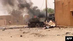FILE - Smoke and flames ascend from an army armored vehicle in Gao, northwestern Mali, following an explosion on July 1, 2018.