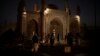 Taliban fighters walk at the entrance of the Eidgah Mosque after an explosion in Kabul, Afghanistan, Oct. 3, 2021. 