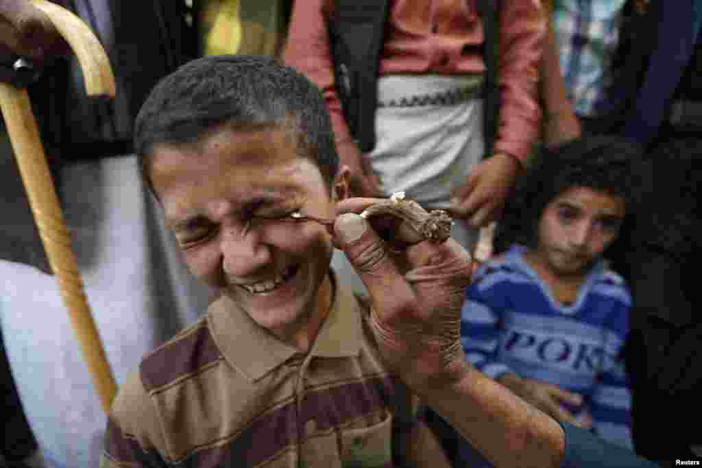 Seorang anak laki-laki memakai kohl, bedak kosmetik yang digunakan untuk perlindungan terhadap sakit mata, di Masjid Akbar di Sana'a, Yaman, 29 Juni 2014. 