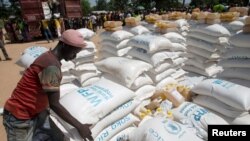 A man carries sacks of food aid delivered by the United Nations Office for the Coordination of Humanitarian Affairs and world food program in the village of Makunzi Wali, Central African Republic, April 27, 2017.