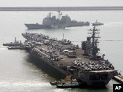 U.S. aircraft carrier USS Ronald Reagan anchors as U.S. Aegis Ship passes after they arrive at Busan port for joint military exercises in Busan, South Korea. The United States and South Korea started joint naval exercises, Nov. 11, 2017.