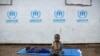 Seorang anak pengungsi asal Sudan Selatan duduk di atas terpal di luar tenda pengungsi di pusat penampungan Impevi di utara Uganda, pada 9 Juni 2017. (Foto: AP/Ben Curtis)