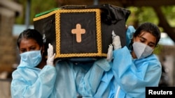 Relawan membawa jenazah seseorang yang meninggal akibat COVID-19 untuk dimakamkan di sebuah pemakaman di Bengaluru, India, 18 Mei 2021. (Foto: Reuters)