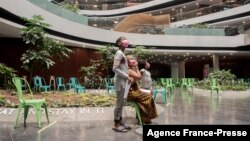 A boy stands with his family in the Discovery vaccination site as he waits to receive his first jab of Pfizer/BioNTech vaccine against COVID-19 in Sandton, Johannesburg, Dec. 15, 2021.