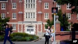 Seorang mahasiswa Universitas Connecticut menunggu lampu lalu lintas berubah di luar gedung asrama di kampus di Storrs, Conn., 18 September 2015. (Foto: AP)