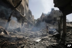 Warga Palestina melihat dampak pengeboman Israel di kamp pengungsi Nuseirat, Jalur Gaza, Sabtu, 8 Juni 2024. (Foto: AP)