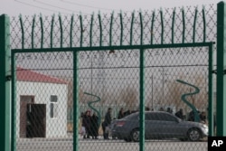 FILE - Residents line up inside a vocational training center in Artux, in western China's Xinjiang region, Dec. 3, 2018. Critics say China uses some of these facilities as detention camps for forced labor.