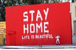 Dance instructor Morgan Jenkins makes a video in front of a mural amid the global outbreak of the coronavirus disease in Los Angeles, California, U.S., on April 3, 2020.