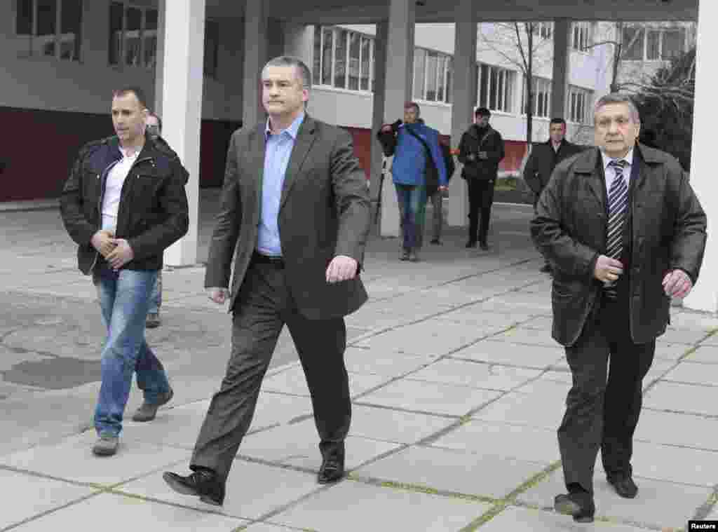 Perdana Menteri Krimea Sergei Aksyonov (tengah) pergi setelah memberikan suaranya dalam referendum di tempat pemungutan suara di Simferopol, Krimea, Ukraina, 16 Maret 2014.