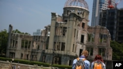 Foreign visitors rest near Atomic Bomb Dome in Hiroshima, western Japan, Aug. 5, 2015.