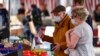 Orang lanjut usia menggunakan masker untuk melindungi dari virus corona tengah berbelanja di pasar di Aachen, Jerman, Kamis, 9 April 2020. (Foto: AP)
