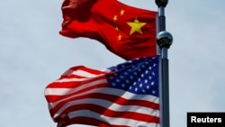 FILE - A Chinese and U.S. flag flutter near The Bund, before U.S. trade representatives meet with their Chinese counterparts for talks in Shanghai, China, July 30, 2019.