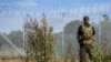 Stražar stoji pored granične ograde sa bodljikavom žicom na granici Letonije sa Rusijom, 16. avgust, 2024. (Foto: AFP/Gints Ivuskans)