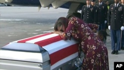 FILE - In this frame from video, Myeshia Johnson cries over the casket in Miami, Florida, Oct. 17, 2017, of her husband, Sgt. La David Johnson, who was killed in an ambush in Niger. 
