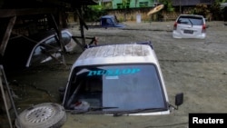 Mobil-mobil tenggelam akibat bencana banjir dan tanah longsor di Sentani, Papua hari Minggu (17/3). (Foto. Antara/Gusti Tanati)