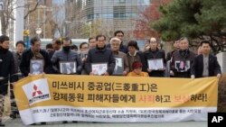 Victims of Japan's forced labor and their family members arrive at the Supreme Court in Seoul, South Korea, Nov. 29, 2018. The sign reads " Mitsubishi Heavy Industries apologize and compensate victims."