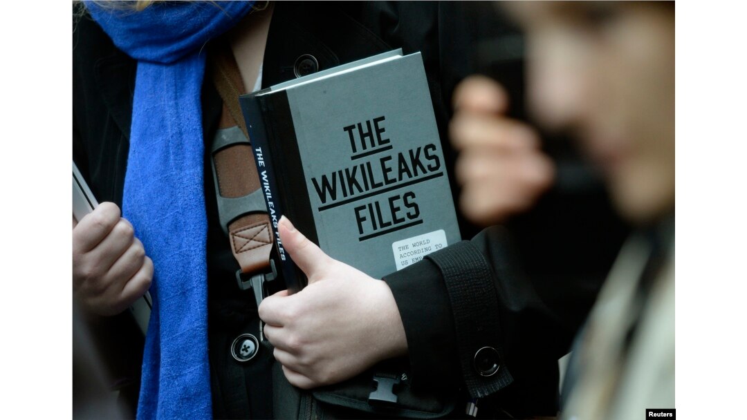 A supporter of WikiLeaks founder julian Assange holds a copy of The WikiLeaks Files outside the Ecuadorian embassy in central London, Britain Feb. 5, 2016.