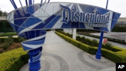 FILE - In this file photo taken Wednesday, March 18, 2020, one of the normally bustling entrances to the Disneyland resort is vacant due to the coronavirus closure in Anaheim, Calif. Disney is postponing the mid-July reopening of its Southern…