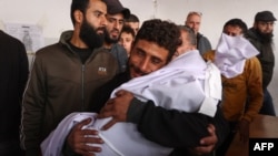Um homem chora enquanto segura o corpo de uma criança de dois anos que foi morta por estilhaços na sequência de um ataque israelita na Cidade de Gaza, no hospital árabe Al-Ahli, a 5 de dezembro de 2024