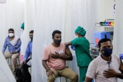 People are administered COVID-19 vaccine in Mumbai, India, April 13, 2021. The country of almost 1.4 billion people is seeing a crippling surge of infections that is threatening to overwhelm hospitals in hard-hit cities.
