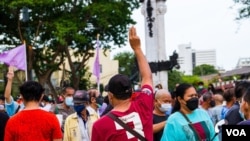 Seorang pedemo mengacungkan salam tiga jari sebagai tanda perlawanan dalam demo anti-pemerintah di Bangkok, Thailand, 26 Juni 2021. (Tommy Walker/VOA)