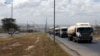 FILE - Trucks drive along the main road from the port city of Mombasa in the outskirts of Kenya's capital, Nairobi, March 4, 2016.