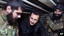 Presiden Suriah Bashar Assad, tengah, berbicara dengan pasukan Suriah ketika berkunjung ke distrik Jobar, Damaskus. (Foto: dok.)