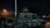 FILE - Greek soldiers are seen on a military vehicle at the Kastanies border crossing with Turkey's Pazarkule, in Kastanies, Greece, March 12, 2020. 