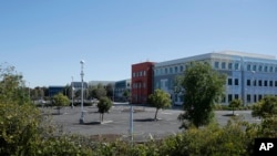 FILE - A nearly empty parking lot is shown at Facebook headquarters in Menlo Park, Calif., April 14, 2020. Tech companies have sent home human moderators and must rely on automated systems.