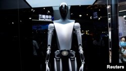资料照片:特斯拉机器人于2023年7月6日在中国上海举行的世界人工智能大会(WAIC)上展示。官媒新华社10月2日表示将出台支持政策,持续推动中国智能网联汽车产业高质量发展。中国智能汽车行业面临着地缘政治阻力以及来自特斯拉等西方同行在改进技术方面的激烈竞争。 (路透社图片)