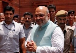 FILE - India's newly appointed Home Minister Amit Shah greets the media upon his arrival at the home ministry in New Delhi, India, June 1, 2019.
