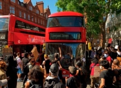 Demonstrators stop a bus as they block the street in Sloane Square in London on May 31, 2020 after marching on the US embassy to protest the death of George Floyd, an unarmed black man who died after a police officer knelt on his neck for nearly…