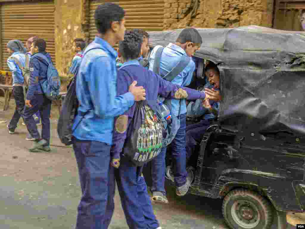 School students are hustling to get into a toktok. After many toktok' accidents raised the passengers' mortality, many Egyptians started to re-think riding toktoks. The majority of toktok drivers are very young to drive. (H. Elrasam/VOA)