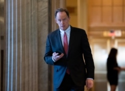 FILE - Sen. Pat Toomey, R-Pa., returns from a break in the impeachment trial of President Donald Trump on charges of abuse of power and obstruction of Congress, at the Capitol in Washington, Feb. 3, 2020.