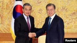문재인(오른쪽) 한국 대통령이 지난 2019년 청와대에서 왕이 중국 외교담당 국무위원 겸 외교부장을 접견하고 있다. (자료사진)
