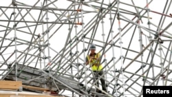 A worker pulls a rope atop the dome of the Jefferson Memorial which is undergoing a 15-month restoration project in Washington, Aug, 26, 2019. 