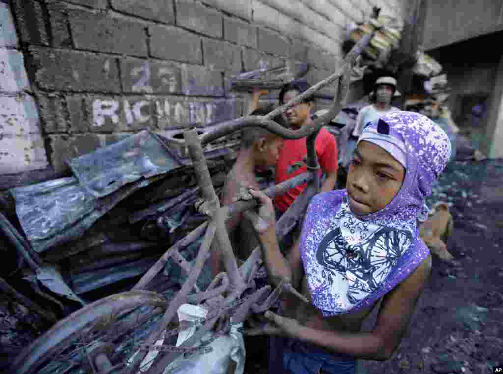 Seorang anak laki-laki, yang kehilangan rumahnya ketika terjadi kebakaran besar pada hari tahun baru, membawa sebuah sepeda yang terbakar di pinggiran kota Quezon city, Manila utara, Filipina. Kebakaran, yang diyakini dipicu oleh petasan itu, menghancurkan ratusan rumah pada hari Kamis, dan merupakan salah satu dari belasan kebakaran yang dilaporkan terjadi di seluruh Filipina ketika warga negara itu menyambut tahun baru. 