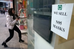 A woman walks into a pharmacy to purchase N95 face masks in advance of the potential coronavirus outbreak in New York City, Feb. 27, 2020.