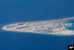 FILE - In this April 21, 2017, file photo, an airstrip, structures and buildings on China's man-made Subi Reef in the Spratly chain of islands in the South China Sea are seen from a Philippine Air Force C-130 transport plane.