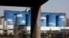 FILE - A commercial plant painted with scenes of clouds and blue skies is seen amid a residential area of Beijing, China.